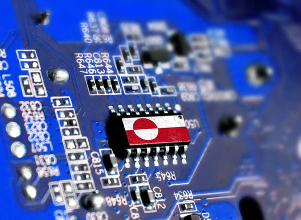 Electronic board with embedded microchip and shown flag of Greenland. The concept of modern computer technologies.