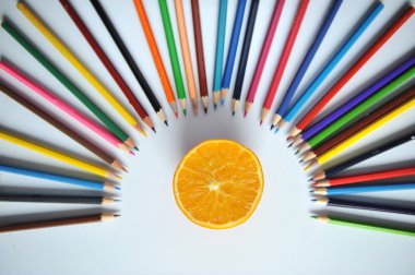 turuncu renkli kalemler ve beyaz zemin üzerine talaşı ile