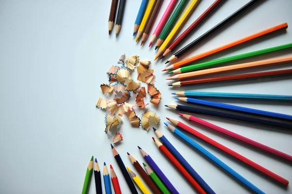Цветные карандаши и стружки на белом фоне — стоковое фото