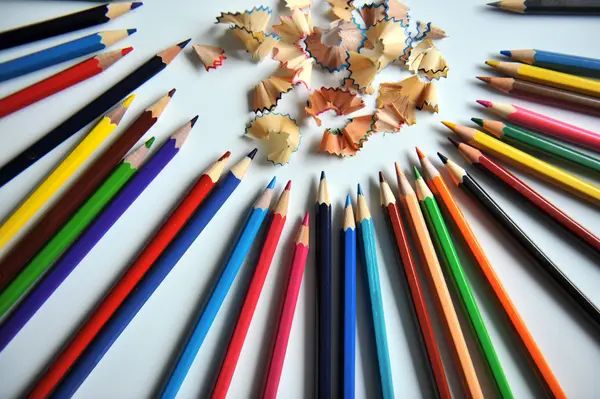 Цветные карандаши и стружки на белом фоне — стоковое фото