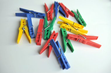 Beyaz arka plan üzerinde çok renkli clothespins dönüştürün