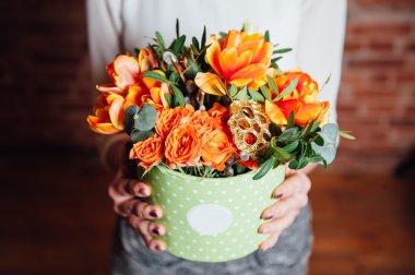 bir sandalyeyle bahar çiçekleri sepeti