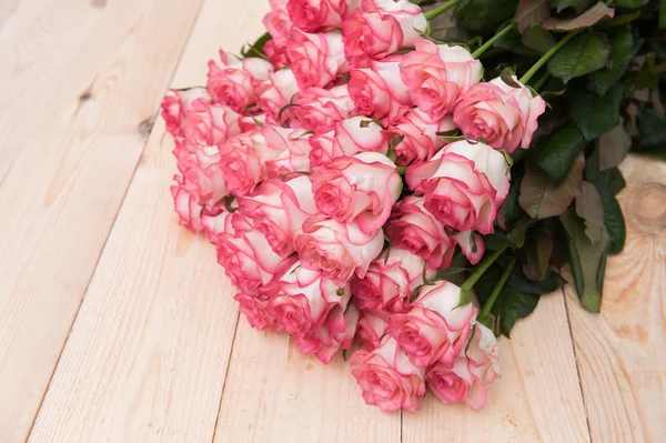 Prachtige roze rozen op een donkere houten tafel — Stockfoto