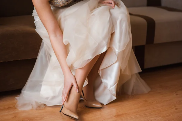 Vackra brudar fötter i skor och vit klänning — Stockfoto