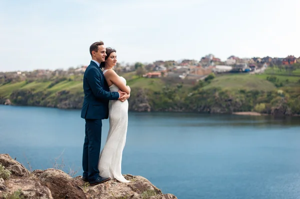 Bride and groom walking at the river — Stock Photo, Image