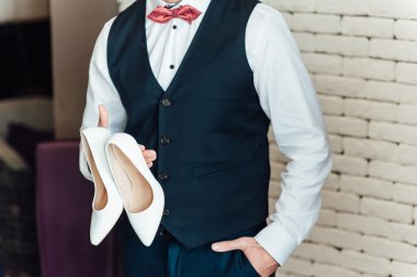 bir damat gelin ayakkabıları tutan görüntüsünü