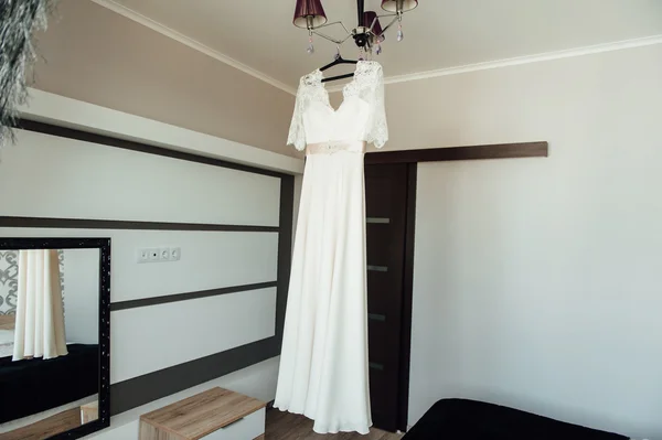 Vestido de casamento branco bonito pendurado pela janela — Fotografia de Stock