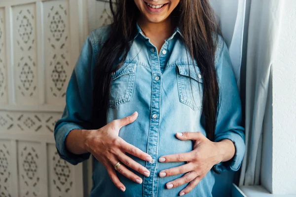 Süße Erwartung einer Schwangeren im Jeanshemd. — Stockfoto