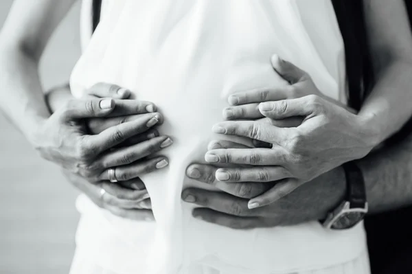 Feliz e jovem casal grávida abraçando — Fotografia de Stock