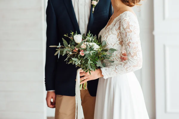 Невеста и жених вместе держат свадебный букет — стоковое фото