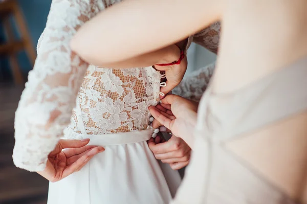 Подружки невесты помогают носить свадебное платье — стоковое фото
