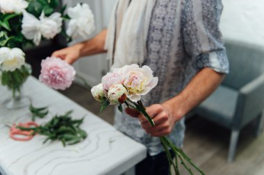 Erkek çiçekçi peones buket hazırlanıyor