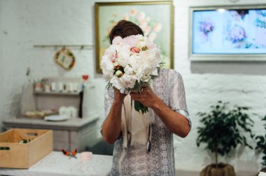 Erkek çiçekçi peones buket hazırlanıyor