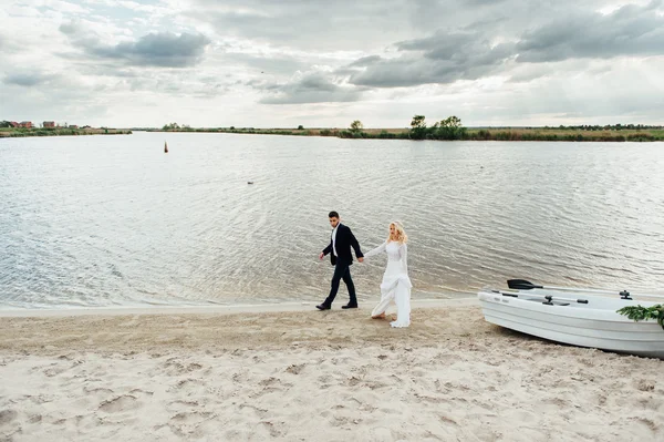 Novia y novio caminando cerca del barco en el río —  Fotos de Stock