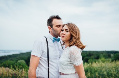 Mutlu gelin ve damat yeşil çimenlerin üzerinde yürüyüş