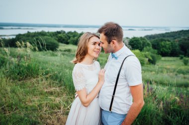 Mutlu gelin ve damat yeşil çimenlerin üzerinde yürüyüş