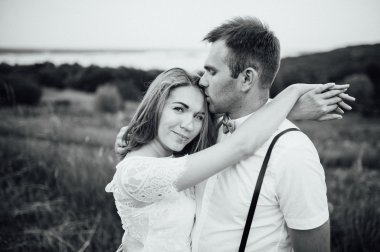 Mutlu gelin ve damat yeşil çimenlerin üzerinde yürüyüş