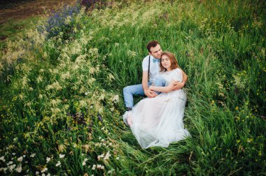 Mutlu gelin ve damat yeşil çimenlerin üzerinde yürüyüş