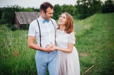 Mutlu gelin ve damat yeşil çimenlerin üzerinde yürüyüş