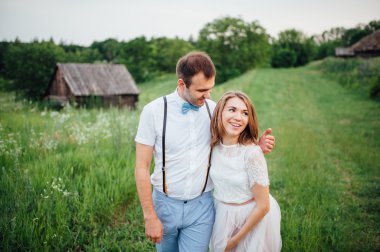 Mutlu gelin ve damat yeşil çimenlerin üzerinde yürüyüş