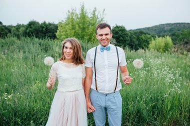 Mutlu gelin ve damat yeşil çimenlerin üzerinde yürüyüş