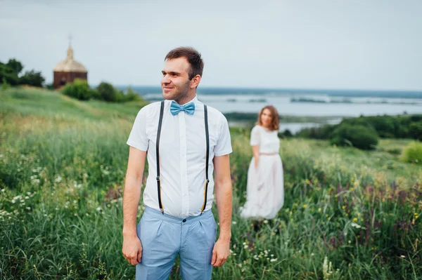 Mariée heureuse et marié marchant sur l'herbe verte — Photo