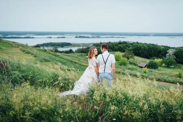 Feliz novia y novio caminando sobre la hierba verde —  Fotos de Stock
