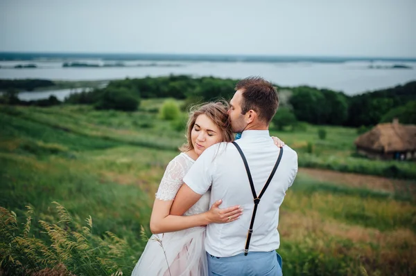 Happy Bride and groom walking on the green grass — Stock Photo, Image