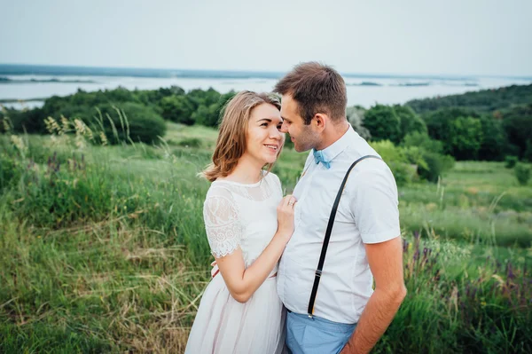 Mutlu gelin ve damat yeşil çimenlerin üzerinde yürüyüş