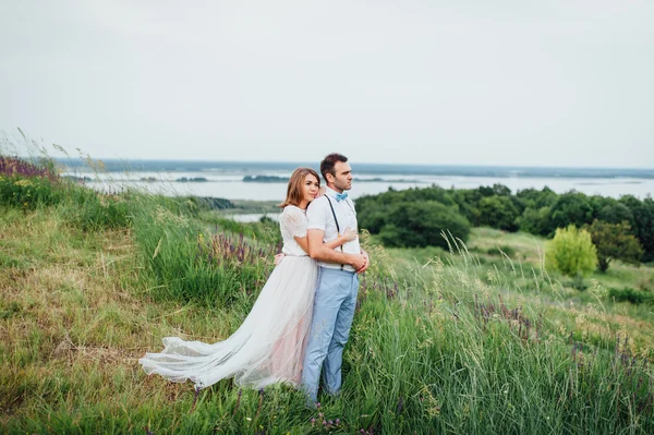 Feliz novia y novio caminando sobre la hierba verde —  Fotos de Stock