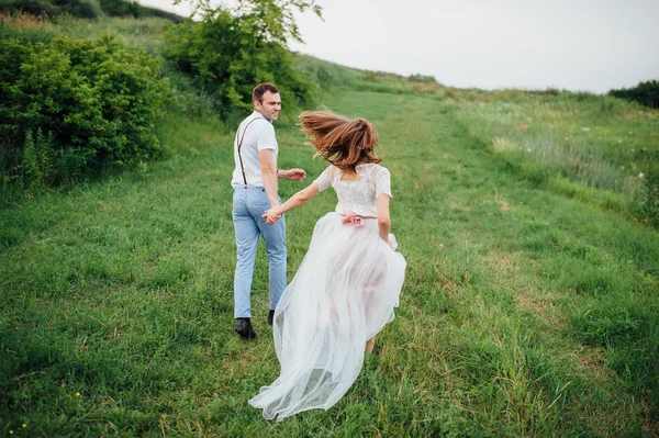Glückliche Braut und Bräutigam auf dem grünen Gras — Stockfoto