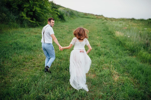 Felice Sposa e sposo a piedi sull'erba verde — Foto Stock