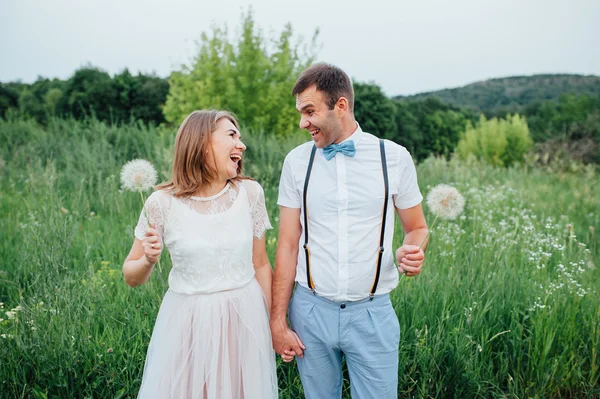 Feliz novia y novio caminando sobre la hierba verde — Foto de Stock