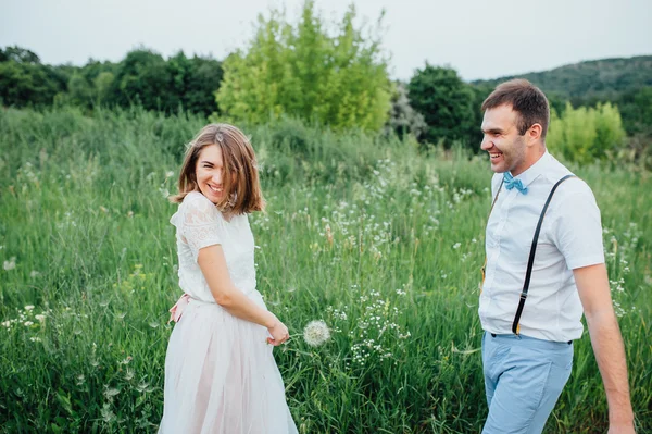 Mariée heureuse et marié marchant sur l'herbe verte — Photo