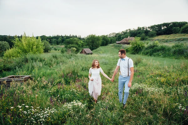 Gelukkige bruid en bruidegom lopen op het groene gras — Stockfoto