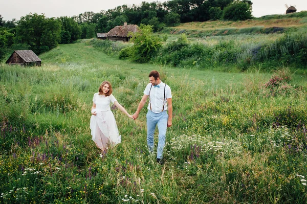 Noiva feliz e noivo andando na grama verde — Fotografia de Stock