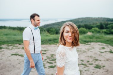 Mutlu gelin ve damat yeşil çimenlerin üzerinde yürüyüş