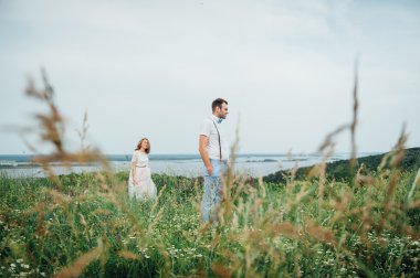 Mutlu gelin ve damat yeşil çimenlerin üzerinde yürüyüş