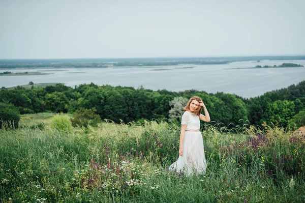 Красива дівчина в білій сукні лежить в зеленій траві — стокове фото