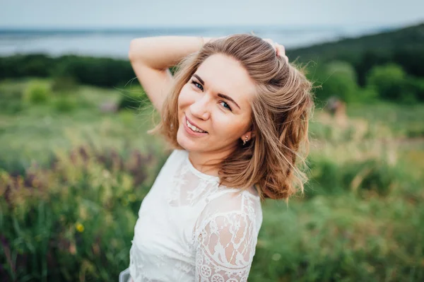 Menina bonita em vestido branco encontra-se na grama verde — Fotografia de Stock