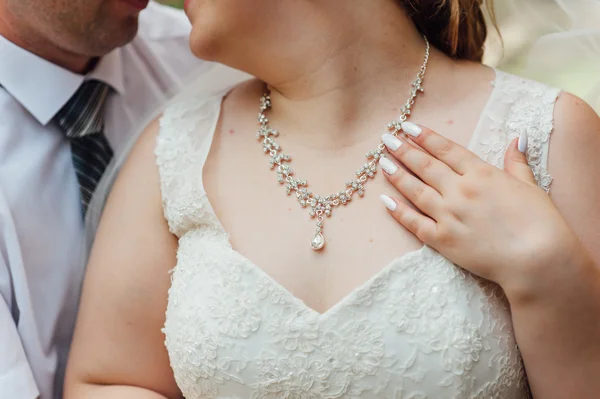 şişman gelin onun boynuna bir kolye takıyor