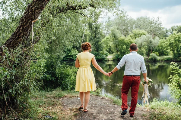 Lovers håller händer och gå i parken — Stockfoto