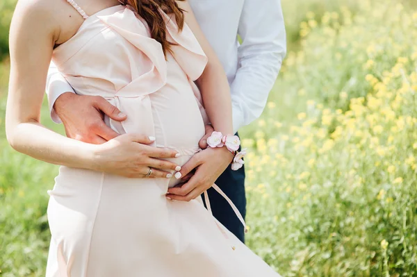Glückliches und junges schwangeres Paar beim Umarmen — Stockfoto