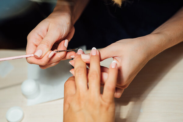 Женщина в салоне получает маникюр
