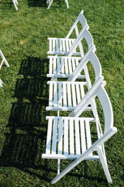 Satır katlama sandalyeler çimenlerin üzerine beyaz