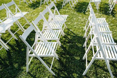 Satır katlama sandalyeler çimenlerin üzerine beyaz