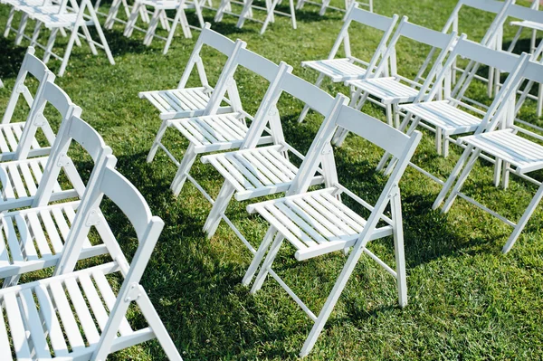 Satır katlama sandalyeler çimenlerin üzerine beyaz — Stok fotoğraf