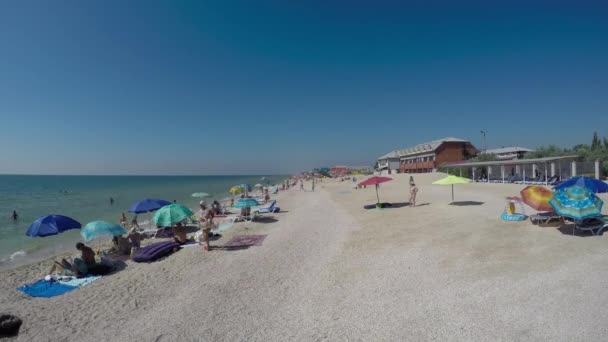 Persone sulla spiaggia in giornata calda e soleggiata — Video Stock