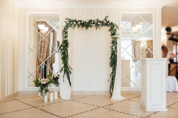Vit bröllop arch dekorerad med blomma inomhus — Stockfoto