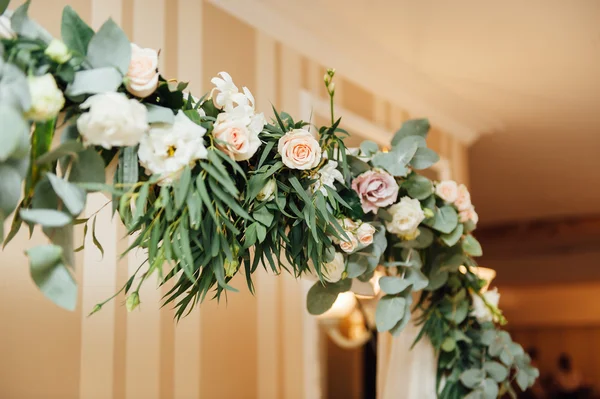 Witte huwelijksboog versierd met bloem binnen — Stockfoto